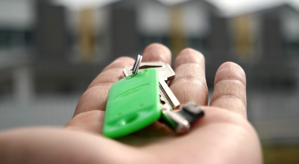 A hand holding a key to a home that was purchased with a portfolio loan.