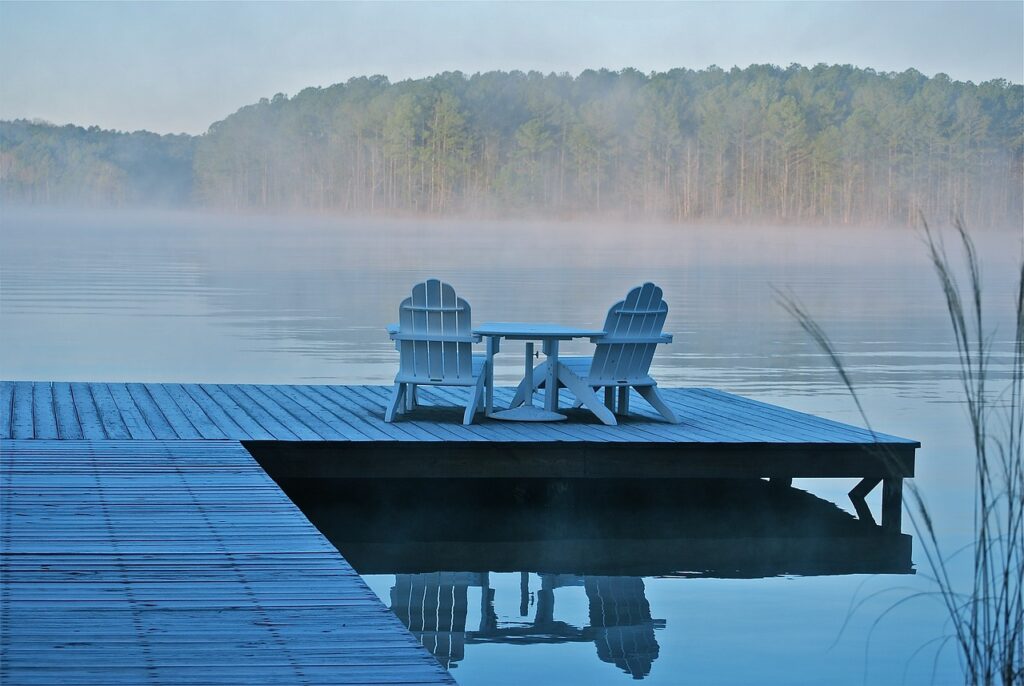 Mortgages for Vacation Homes: How to Get One 3 Two adirondack chairs are sitting on a dock at a cottage, which was financed using mortgages for vacation homes.