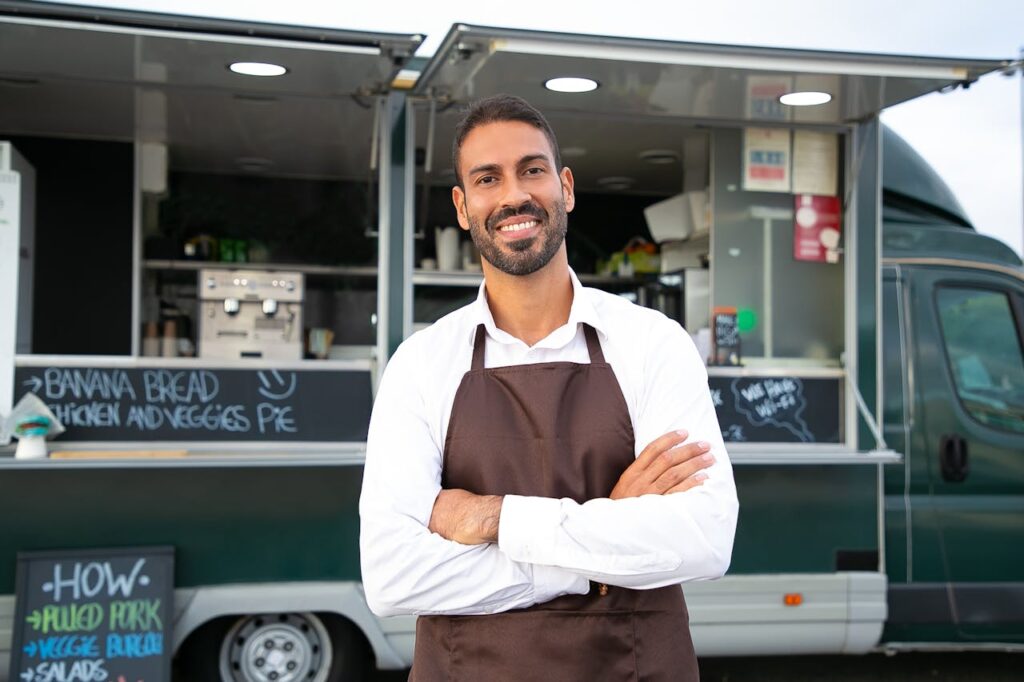 A business owner who's standing in front of his food truck -- an ideal candidate for California P&L loans.