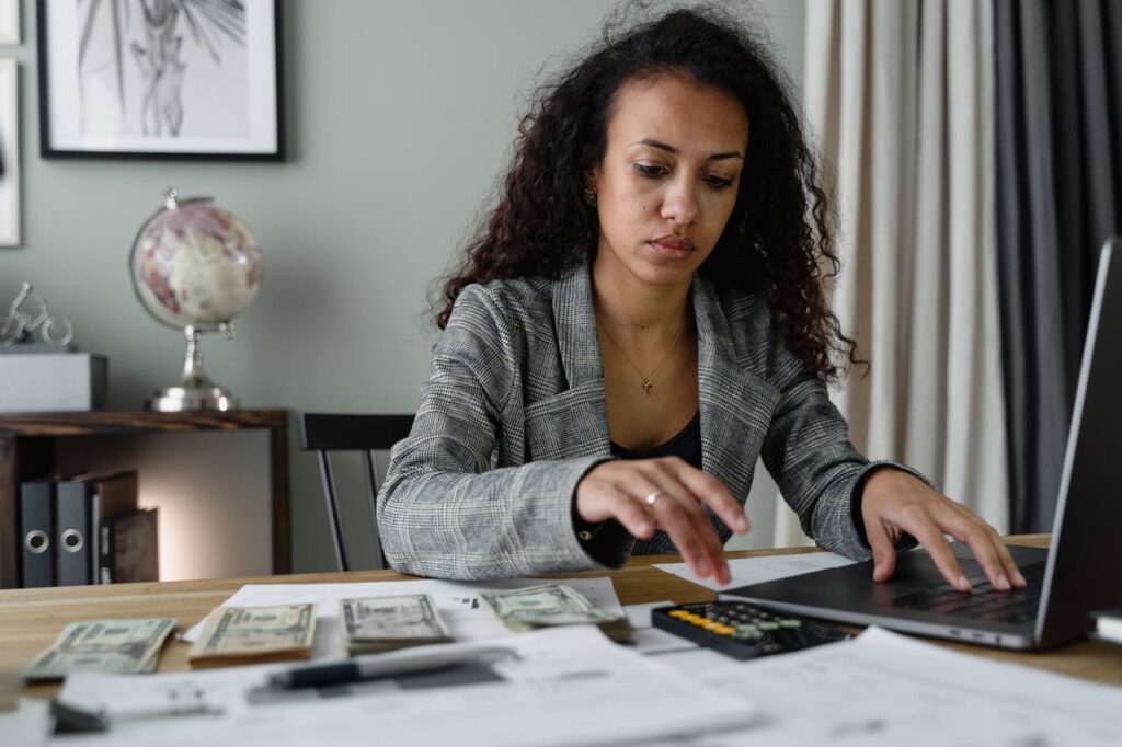 California Construction Loans: The Complete Guide 3 A woman is sitting at a desk, budgeting and calculating her finances to prepare to apply for a California construction loan.
