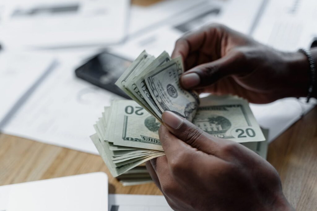 Cash-Out Refinance for Investment Properties: How It Works 3 A person is counting the bills they got from a cash-out refinance for investment properties.