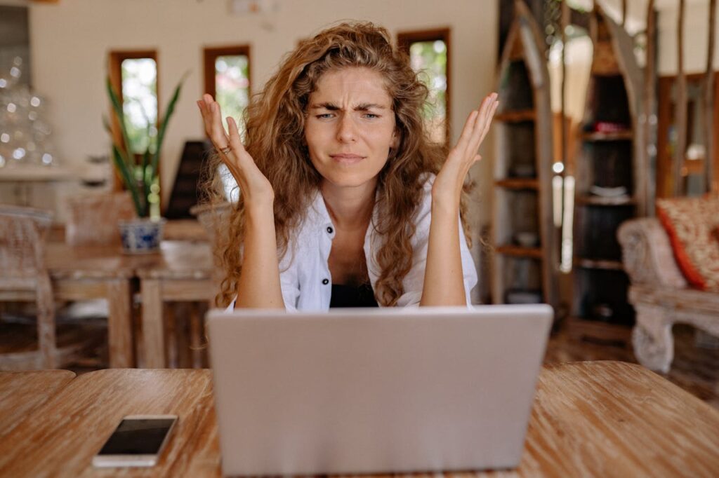 Mortgage Interest Rates: What Happens When They Drop? 2 A woman has her hands up in front of her computer, frustrated at how high interest rates have gotten.