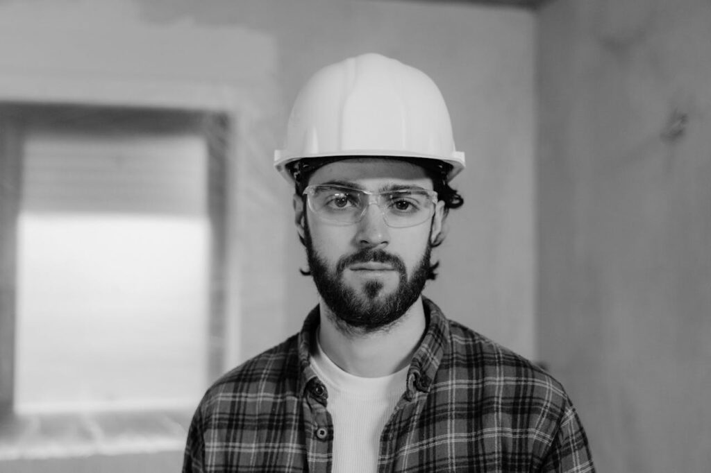 Buyer's Home Inspections: The Complete Guide 2 An inspector is looking at the camera while wearing a hard hat and safety glasses during a home inspection.
