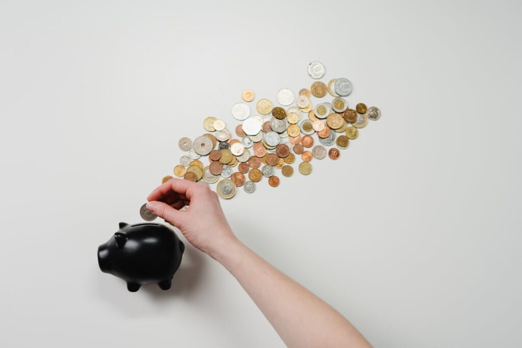 Cash-Out Refinance vs. Home Equity Loans for Real Estate Investors: Why Cash-Out Wins 1 A piggy bank with coins coming out of it to signify unlocking wealth with a cash-out refinance or home equity loan.