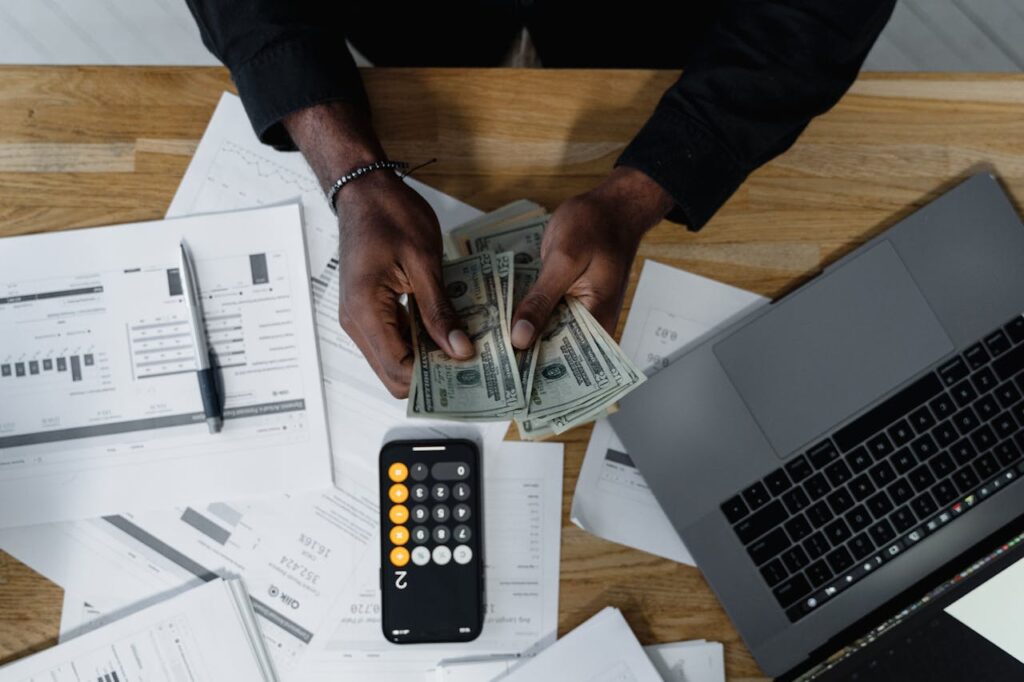 How to Improve Your Credit Score as a Self-Employed Individual for Better Mortgage Rates 2 A man counting cash to pay his bills since he knows that paying bills on time will improve your credit score.