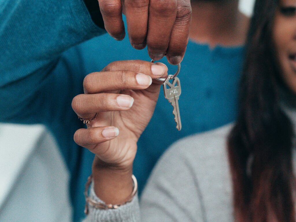 How to Improve Your Credit Score as a Self-Employed Individual for Better Mortgage Rates 4 A couple is holding the key to their new house after following advice on how to improve your credit score.