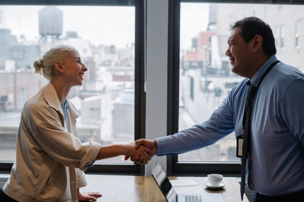 7 Common Myths About Self-Employed Mortgages 3 A customer is shaking hands with a loan officer after debunking myths about self-employed mortgages and finally closing on a home.