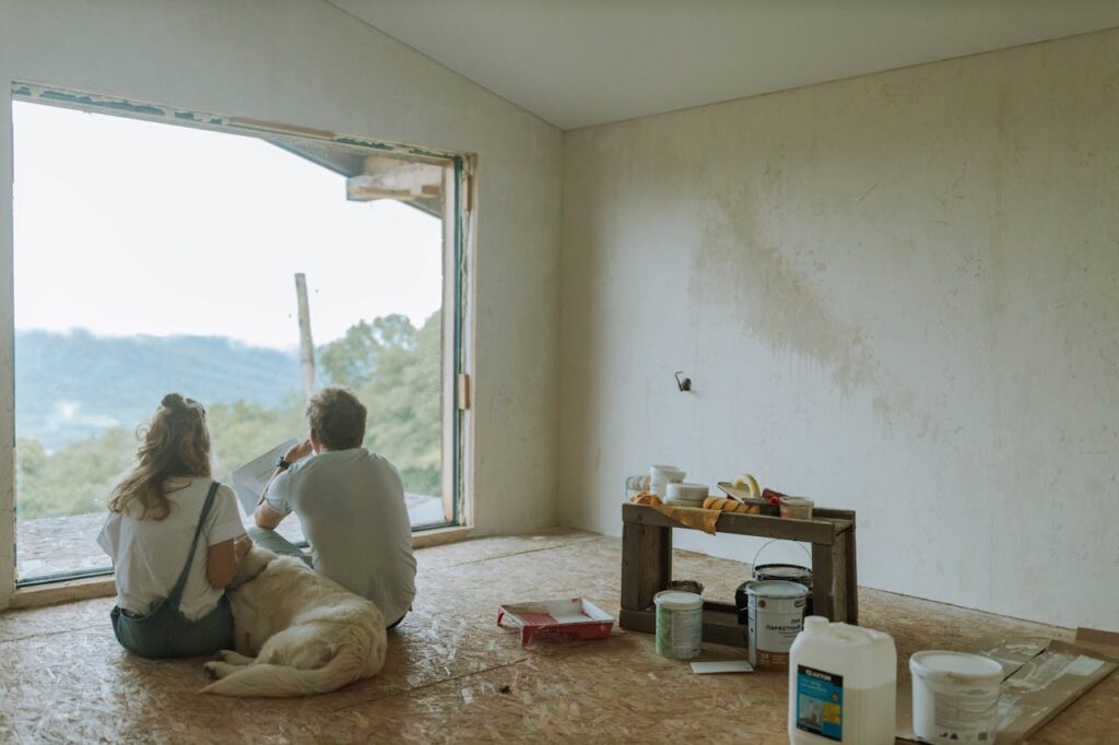 Construction Loan Georgia: How to Finance Your Dream Home 2 A couple sitting in their half-finished new build home that was purchased with a construction loan Georgia.