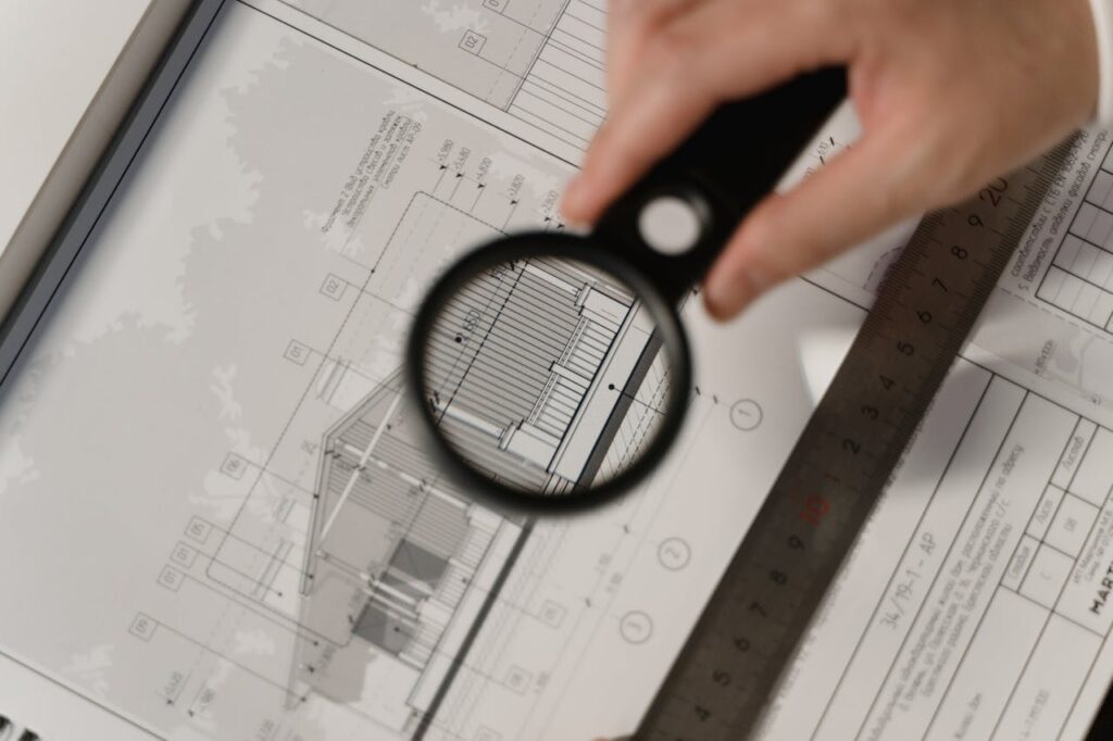 Construction Loan Georgia: How to Finance Your Dream Home 3 A magnifying glass looking over building plans for a new build that's financed by a construction loan Georgia.