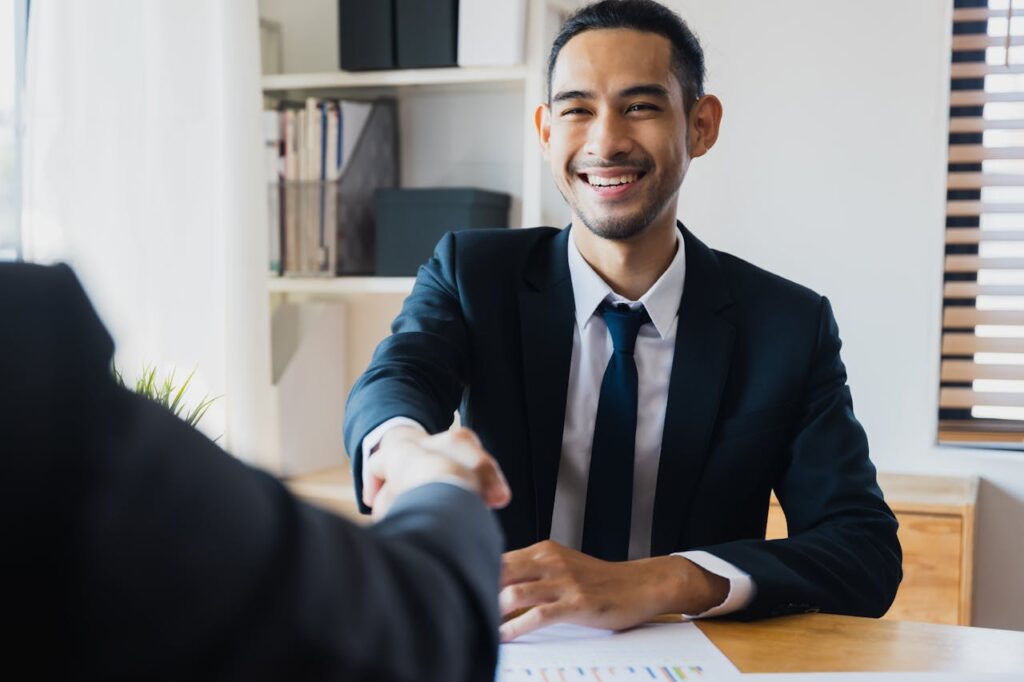 Jumbo Loan Georgia Guide: Maximize Your Home Buying Power 3 A mortgage loan officer is shaking a client's hand after closing the deal on their new jumbo loan Georgia home.