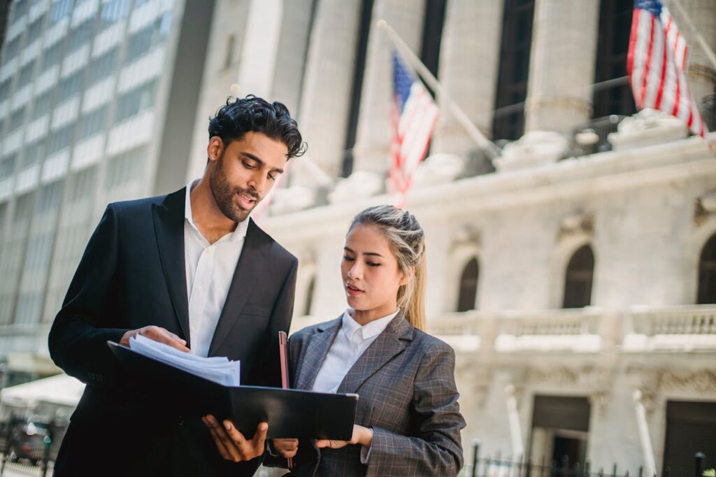 Foreign National Loans California: Non-US Citizen Financing 1 Two non-U.S. citizen real estate investors are reviewing papers for their foreign national loans California outside a bank building.