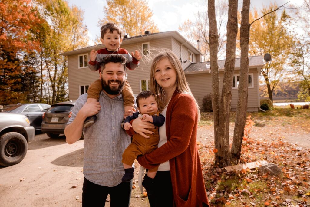 How an Investment Property Can Secure Your Financial Future 2 A young couple with two young children are standing in front of their new home.
