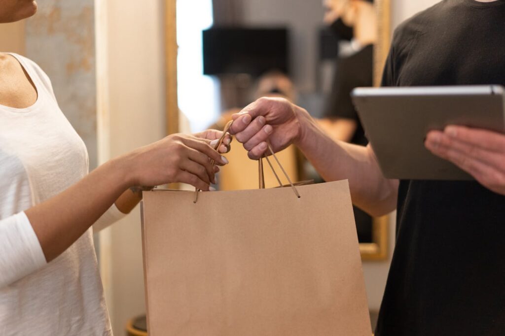 What Is the Fed Rate Cut? An Inside Look into Interest Rates 1 A shop owner is handing a shopping bag to a customer after a purchase.