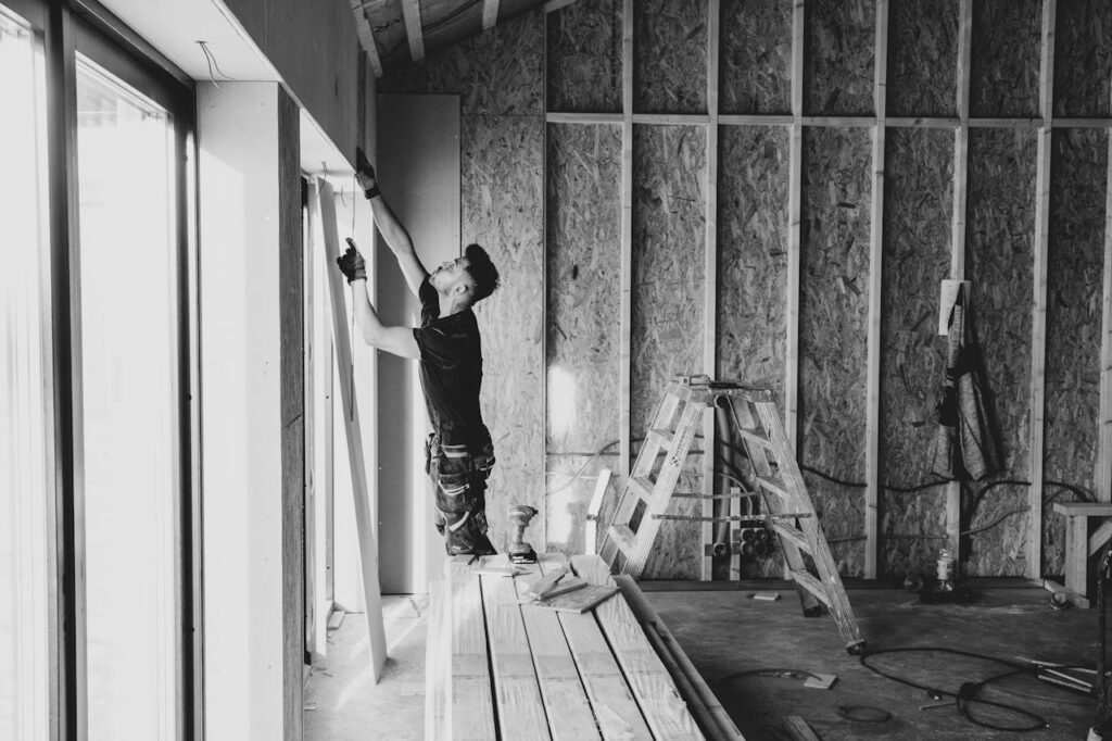 FHA Construction Loan Basics: A Simple Guide 1 A builder measuring a sliding glass door in a house that's under construction and financed using an FHA construction loan.