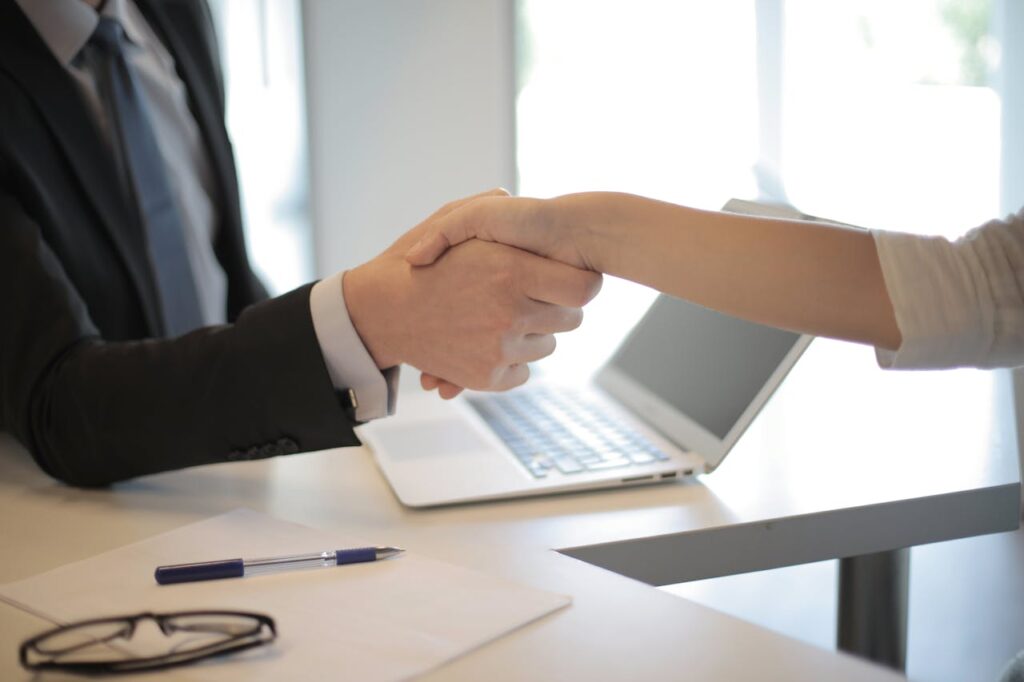 Your Guide to Asset Based Finance for Mortgages 3 A lender shaking hands with a new homeowner after closing an asset based finance deal.