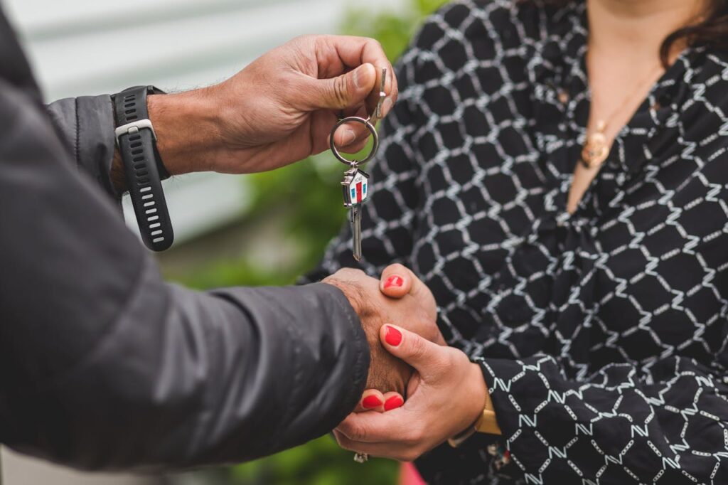 DSCR Loan Nebraska: The Key to Smarter Investments 1 Woman and man shaking hands and exchanging keys after closing on a DSCR loan Nebraska.