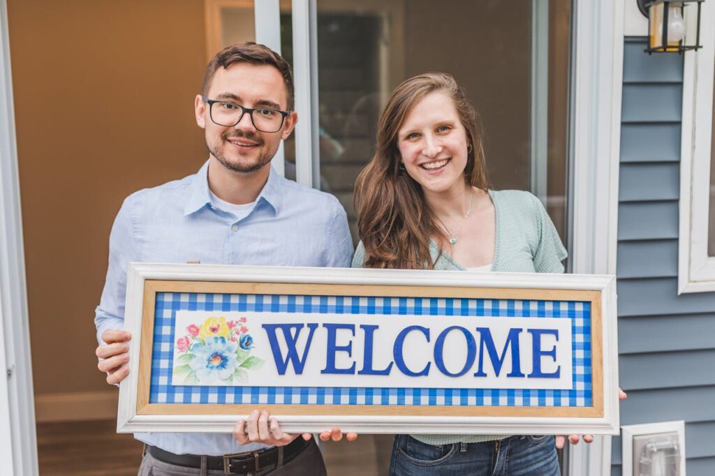 Where to Get a Mortgage: 10 Tips for Choosing the Right Lender 1 A couple is holding a "welcome" sign in front of their new home after figuring out where to get a mortgage.