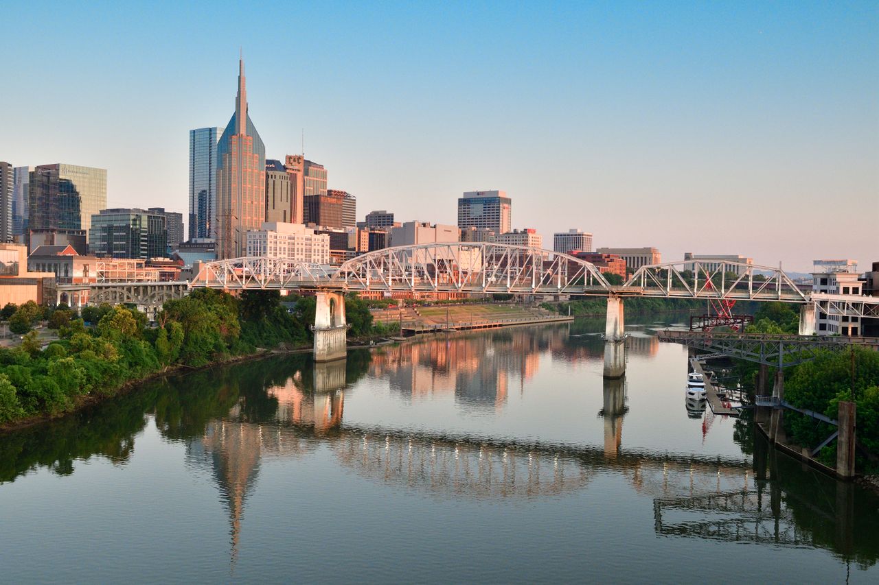 The Digital Deed 21 Nashville skyline at sunrise with a pedestrian bridge in the foreground