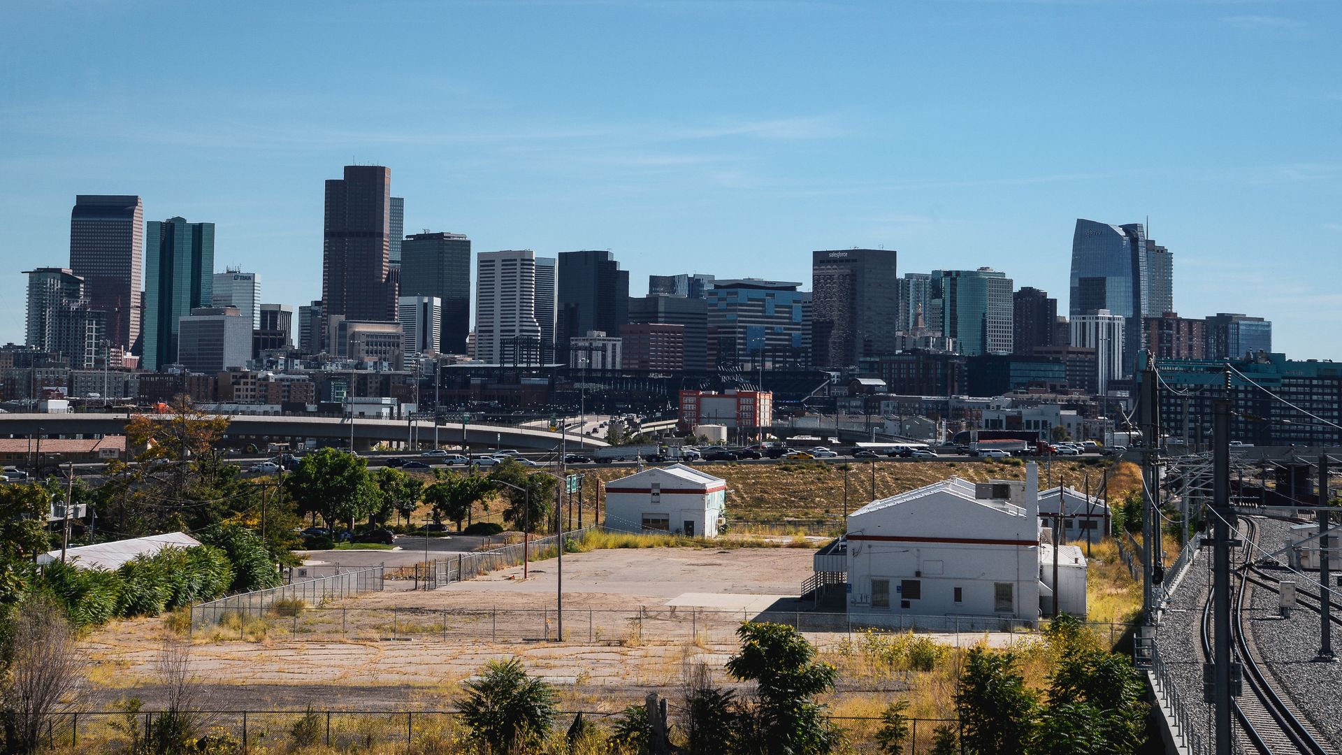 The Digital Deed 31 Downtown Denver skyline viewed across industrial foreground